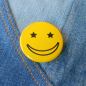 Preview: Ansteckbutton Smiley Sternchenaugen gelb auf Jeans